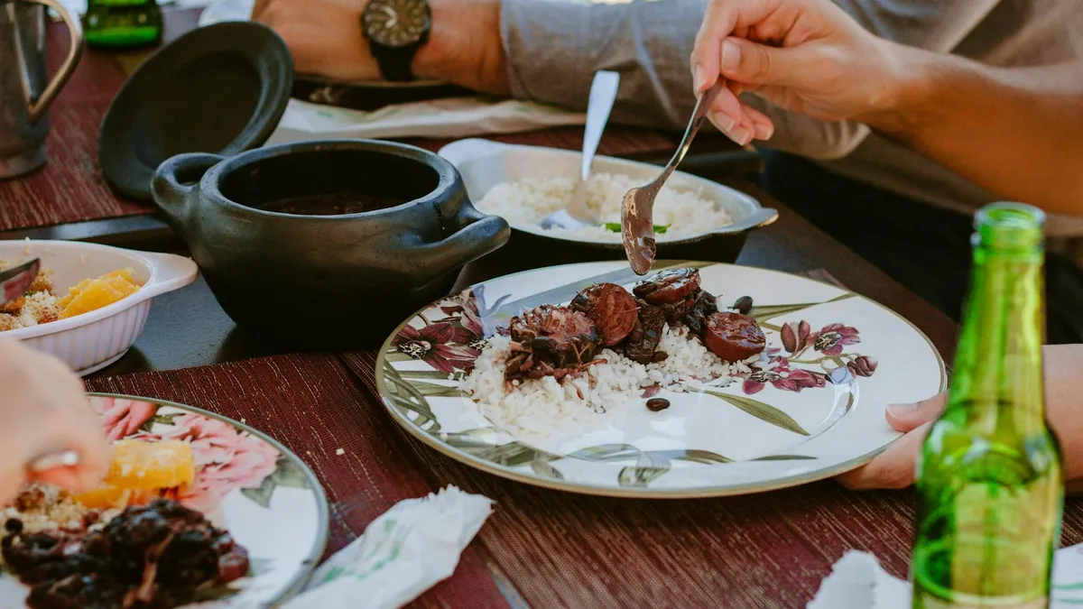 Feijoada brasileña con frijoles negros, carne de cerdo, arroz blanco y couve refogada
